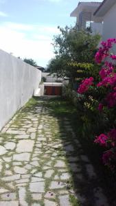 a stone pathway with pink flowers next to a building at Villa Bungaville a Olbia in Olbia
