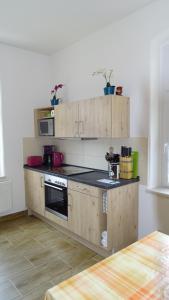 a kitchen with wooden cabinets and a stove at Ferienwohnung "Möller" in Rathmannsdorf