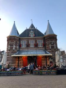 un gran edificio con gente parada frente a él en PH93 Amsterdam Central, en Ámsterdam