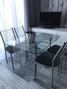 una mesa de cristal y sillas en la sala de estar. en Apartament Villa Marea en Międzyzdroje