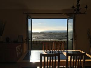a dining room table with a view of the ocean at B2 Waterfoot Apartment in Newcastle