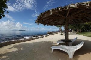 una sedia sotto un ombrellone in spiaggia di Island Magic Resort Apartments a Port Vila