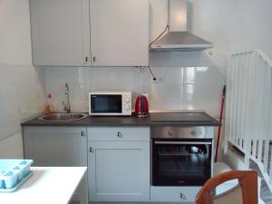a small kitchen with a sink and a microwave at Apartment More Sumartin in Sumartin