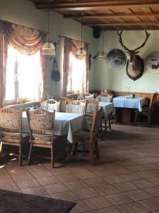 a dining room with tables and chairs and windows at Hotel-Pension Am Mühlberg in Lübbenau