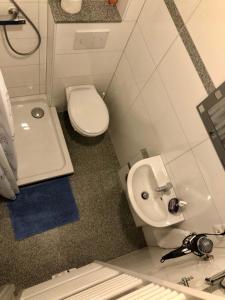 La petite salle de bains est pourvue de toilettes et d'un lavabo. dans l'établissement Gästehaus Buonanotte 2, à Brême