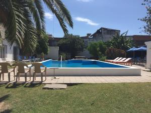 a swimming pool in a yard with chairs and a table at Alto Rio Hondo in Termas de Río Hondo