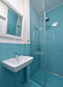 y baño con lavabo y ducha acristalada. en Designer Loft 2, en Praga