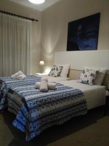 1 dormitorio con 1 cama con manta azul y blanca en Lagoa´s House, en Lagoa