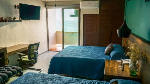 1 dormitorio con cama, escritorio y ventana en Hotel Caracoles, en Manzanillo