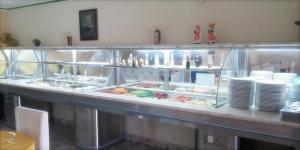 a buffet line in a restaurant with plates and food at Milleniu's Pousada e Restaurante in Piranhas