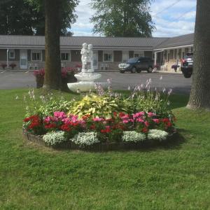 a flower garden with a statue in a park at Tay Inn in Perth
