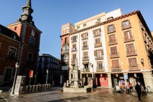 マドリードにあるCharming Madrid Plazaの通りの真ん中に像のある建物