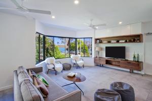 a living room with a couch and a tv at Aarons Luxury Retreat in Noosaville