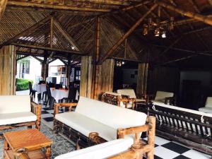 a restaurant with white chairs and tables and a checkered floor at Hotel Campestre VillaMaria in Vergara