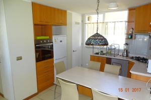 a kitchen with a white table and chairs in it at Departamento 102 Alicante in Papudo