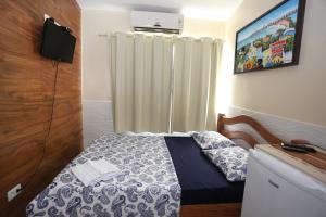 a small bedroom with a bed and a curtain at Paraíso Olindense in Olinda