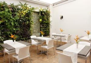a room with tables and chairs and plants at Hotel M Boutique in Villeta