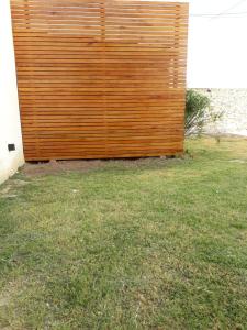 una valla de madera en un patio junto a un campo de hierba en Loft desing en Paraná