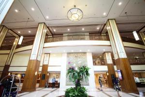 a lobby of a building with a plant in the middle at Redtop Hotel & Convention Center in Jakarta