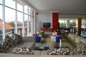 a living room with couches and a flat screen tv at EDU Hostel in Yogyakarta