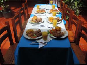 einen langen Tisch mit Teller mit Lebensmitteln drauf in der Unterkunft Monzaque- paraíso de bachué in El Barrial