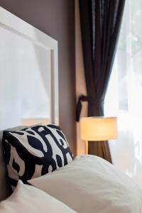 a bed with a black and white pillow and a window at Priuli Luxury Rooms in Split