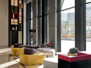 eine Lobby mit Sofas und Stühlen und einem großen Fenster in der Unterkunft Novotel Ambassador Seoul Yongsan in Seoul