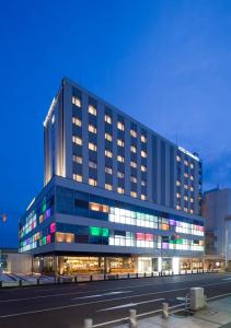 a large black building with many windows at night at Hotel Granbinario Komatsu in Komatsu