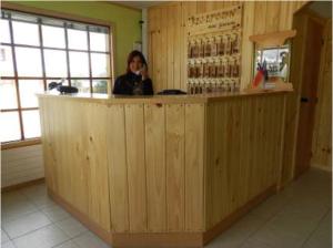 una mujer parada detrás de un mostrador en un bar en Hotel Glaciares en Puerto Natales