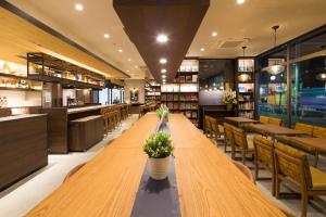a long wooden table in a restaurant with chairs at Hotel Granbinario Komatsu in Komatsu