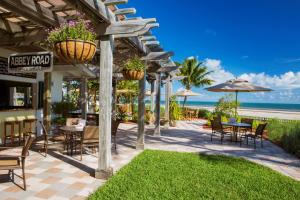 um pátio com cadeiras, mesas e guarda-sóis e a praia em Hyatt Vacation Club at Windward Pointe em Key West