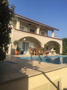 a house with a swimming pool in front of it at Villa Eleni in Lagonissi