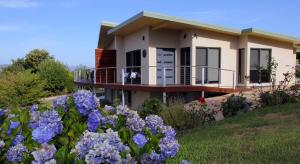 a house with purple flowers in front of it at Ou+look BnB in Rosevears