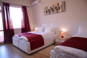 a bedroom with two beds and a window at Hotel Afrodita Dimitrovgrad BG in Dimitrovgrad