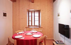 a dining room with a red table and a window at Domaine du Burignon in Saint-Saphorin