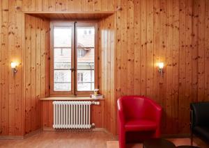 a room with a red chair and a window at Domaine du Burignon in Saint-Saphorin