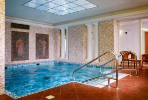 a large swimming pool with a staircase in a room at OREA Spa Hotel Palace Zvon Mariánské Lázně in Mariánské Lázně