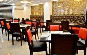 a dining room with tables and chairs in a restaurant at Tyche Boutique Hotel in Legazpi