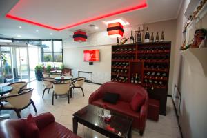 a restaurant with a red couch and tables and wine bottles at Hotel Palma in Rinas