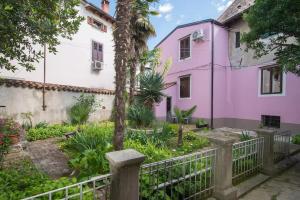 a pink house with a fence in front of it at Charming Apartment in Koper