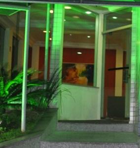 a reflection of a person in the window of a building at Hotel Vollare in Osasco