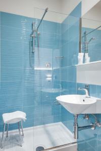 リミニにあるHotel Barbianiの青いバスルーム(シンク、シャワー付)