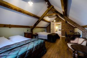 a bedroom with two beds and a table and chairs at Auberge de Smockelaer in Heijenrath