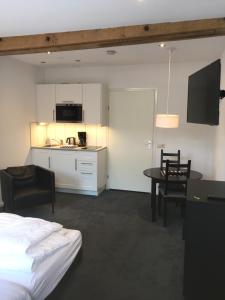 una camera con letto e tavolo e una cucina di Appartementen Rijnhoeve a Koudekerk aan den Rijn