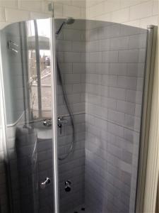 a bathroom with a shower with a glass door at Silbernagel Apartment in Kuressaare