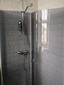 a shower with a shower head in a bathroom at Silbernagel Apartment in Kuressaare