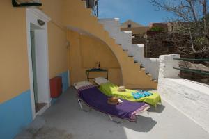 a patio with two beds and a stair case at Villa Petros in Symi