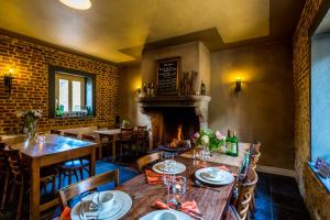 a restaurant with tables and chairs and a fireplace at Auberge de Smockelaer in Heijenrath