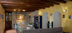 Habitación con mesa, sillas y pared de piedra. en Casa Rural El Pati de l´Albera, en Sant Climent Sescebes