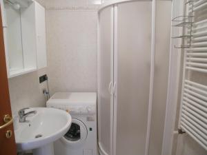 a bathroom with a shower and a sink and a washing machine at Alessia in Grado